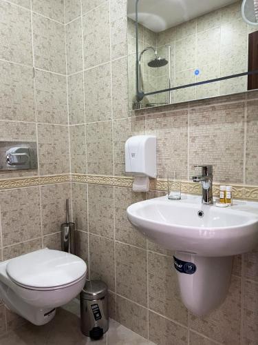 a bathroom with a white sink and a toilet at Clepsydra Residence in Plovdiv