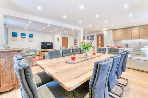 Il dispose d'une cuisine et d'un salon avec une table et des chaises en bois. dans l'établissement Chalet L'Argoat - Warm and cosy 6 bedroom chalet, à Chamonix-Mont-Blanc
