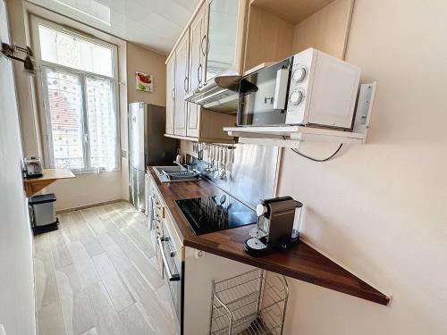 - une cuisine avec un comptoir et un four micro-ondes dans l'établissement ROL2 - Beau 2 pièces avec balcon et vue mer latérale, à Cannes