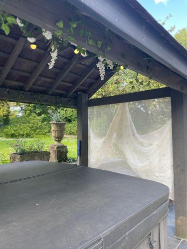 a pergola with a table on a patio at Garden Retreat Wales in Llandowror
