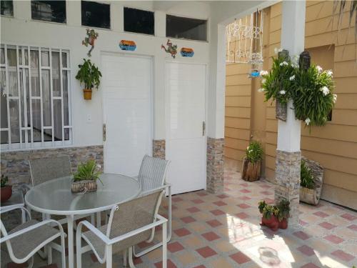 a patio with a table and chairs and plants at Hospedaje solymar III Sarie Bay in San Andrés
