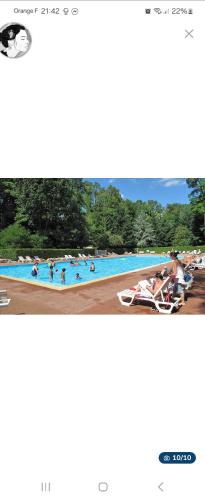 une grande piscine avec des gens dans l'eau dans l'établissement Le paradis du mobilhome, à Saint-Chéron