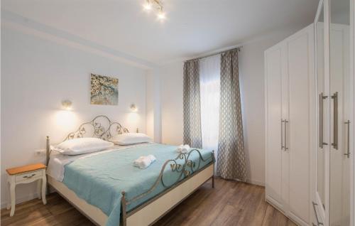 a bedroom with a bed with blue sheets and white pillows at 3 Bedroom Cozy Home In Hrvace in Hrvace