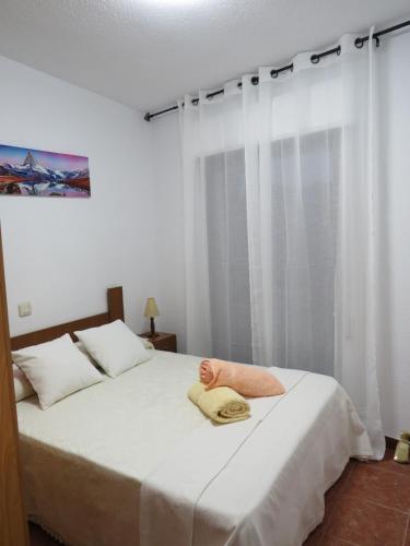 a bedroom with a bed with a hat on it at El portal de Beni in Pedro Bernardo
