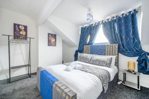 a bedroom with a blue and white bed and a window at -16PT- For your relaxed & Cosy stay & Free Parking in Leeds