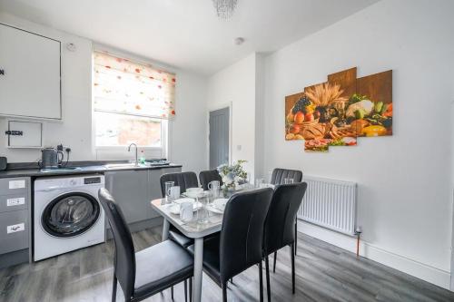 a kitchen and dining room with a table with chairs at -16PT- For your relaxed & Cosy stay & Free Parking in Leeds
