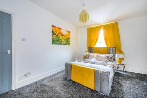 a bedroom with a yellow bed and a window at -16PT- For your relaxed & Cosy stay & Free Parking in Leeds