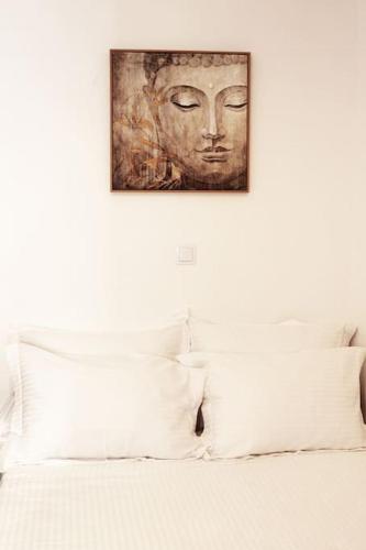 a painting of a face on the wall above a bed at Titinas' in Plomari