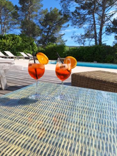 two cocktails sitting on a table next to a pool at Villa Sisyphe chambre"la jeanette" in Le Thoronet