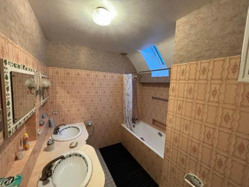 Un baño con lavabo, bañera y espejo. en Agréable maison de ville avec tout à proximité, en Saint-Dizier