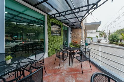 a patio with tables and chairs on a balcony at Hotel La Venta Inn Villahermosa in Villahermosa