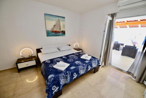 a bedroom with a bed and a sailboat painting on the wall at Apartments Petarcica Beach in Zavala