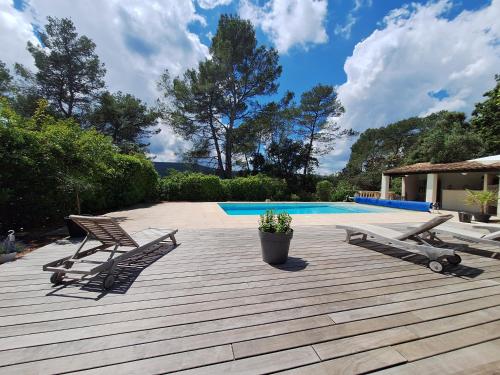 a deck with two chairs and a swimming pool at Villa Sisyphe chambre"la jeanette" in Le Thoronet
