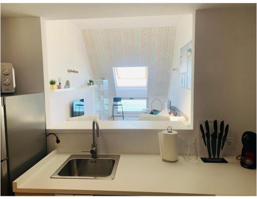 a small kitchen with a sink and a window at Apartamentos LAMAROSA -ATICO ,Vistas al Mar Cantabrico PARKING in Burela de Cabo