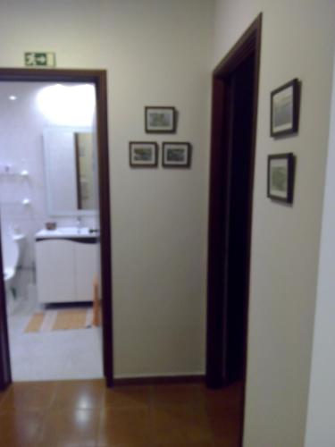 a bathroom with a sink and a door leading into a room at Apartamento Valados in Ponta Delgada