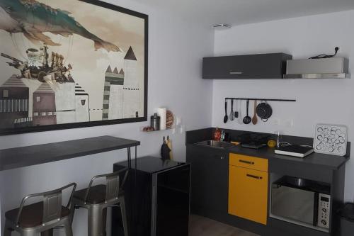 une cuisine avec un comptoir et une armoire jaune dans l'établissement Studio au cœur de l'hyper centre, à Caen
