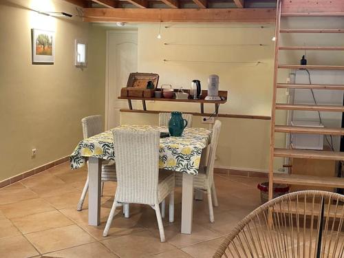 - une salle à manger avec une table, des chaises et une étagère dans l'établissement Maison des hirondelles petit Luberon, à Niozelles
