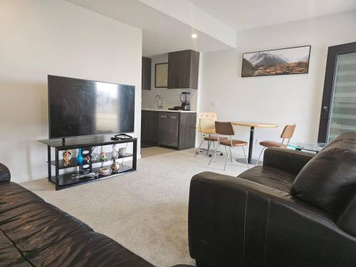 a living room with a couch and a flat screen tv at Praise bethel -Homely walkout legal basement in YYC in Calgary