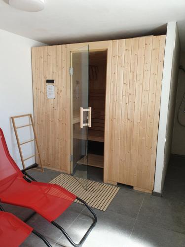 a red chair in a room with wooden lockers at Chalet Valaisia in Riederalp