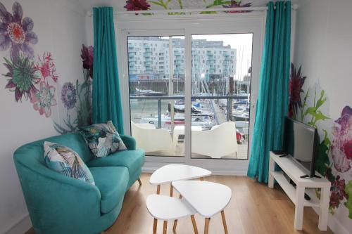a living room with a blue couch and a window at Chic apartment in the heart of Brighton Marina in Brighton & Hove