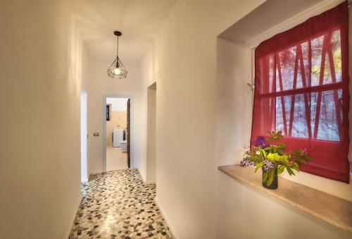 a hallway with a window and a vase with flowers on a shelf at Villa Scoglio in Varenna