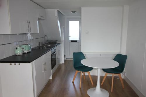 a kitchen with a white table and two chairs at Chic apartment in the heart of Brighton Marina in Brighton & Hove