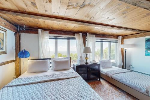 Un dormitorio con dos camas y techo de madera. en Cooper Hill Hideout, en East Dover