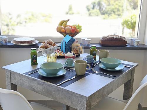a table with plates and cups and a cake on it at Il Portico B&B Capri in Capri