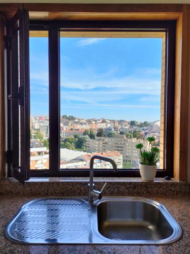 a kitchen sink in front of a large window at Douro View Apartment in Vila Nova de Gaia