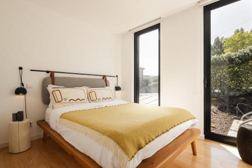 a bedroom with a bed and a large window at Just Like Home - Casal no Campo in Vila Praia de Âncora
