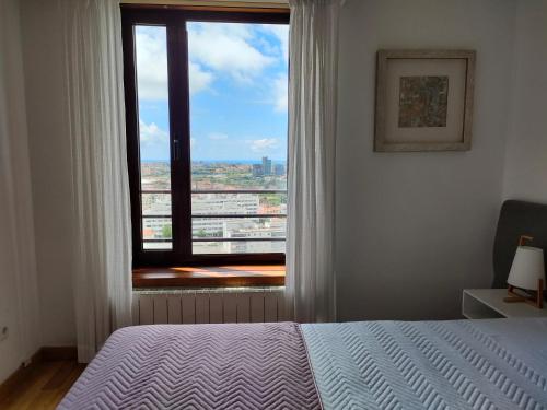 una camera con un letto e una grande finestra di Douro View Apartment a Vila Nova de Gaia