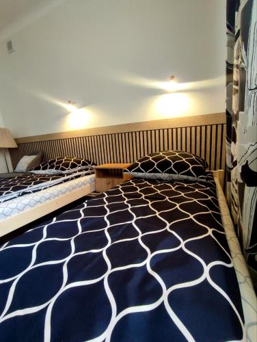 a bedroom with two beds with blue and white sheets at Och!hostel in Gdynia