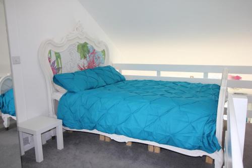 a bedroom with a bed with a blue comforter at Chic apartment in the heart of Brighton Marina in Brighton & Hove