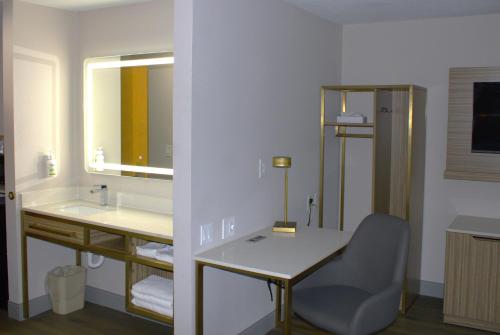 a bathroom with a desk and a sink and a mirror at Baymont Inn & Suites by Wyndham San Marcos in San Marcos
