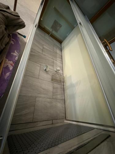 a walk in shower with a glass door in a bathroom at Zimmer Boutique Hotel in Baku