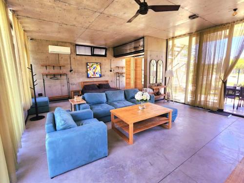 a living room with a blue couch and a table at Nina's house & Yard 200m from beach Kaprovani in Ureki