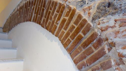 a brick wall with a loophole in it at Ceramic Rooms in Oristano