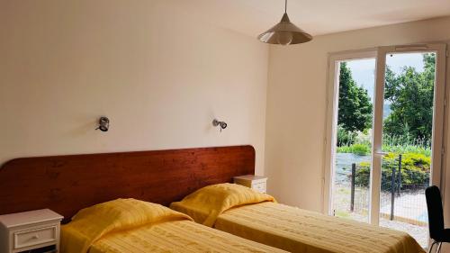 - une chambre avec 2 lits avec des draps jaunes et une fenêtre dans l'établissement Villa avec piscine 3 chambres et 3 salles de bains à Gréoux-les-Bains, à Gréoux-les-Bains
