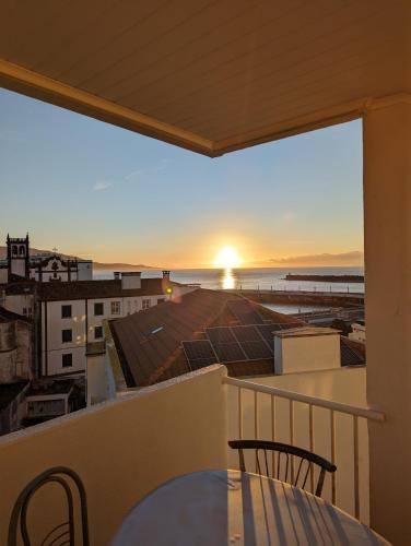 a balcony with a table and chairs and a view of the ocean at Waterfront 1 Bedroom suite 3 adults PDL in Ponta Delgada