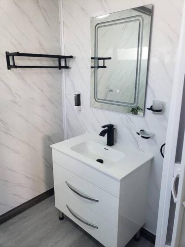 une salle de bains blanche avec un lavabo et un miroir dans l'établissement Los Robles, à Saint-Domingue