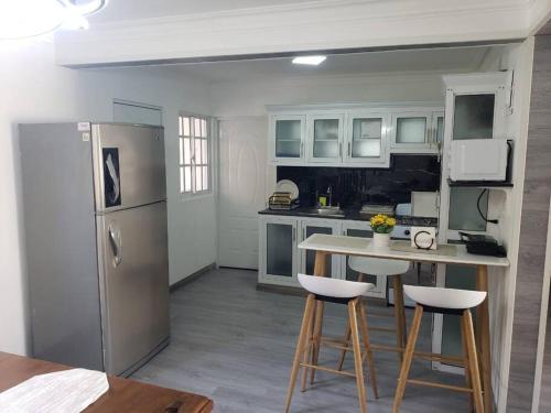 une cuisine avec un réfrigérateur, une table et des tabourets dans l'établissement Los Robles, à Saint-Domingue