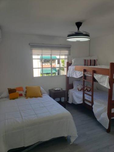 une chambre avec deux lits superposés et une fenêtre dans l'établissement Los Robles, à Saint-Domingue