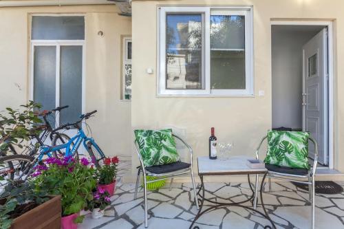 a patio with two chairs and a table with a bottle of wine at The yard in Thérissos