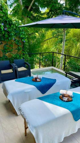 a group of three beds sitting under an umbrella at Botánikal Hotel in Montenegro