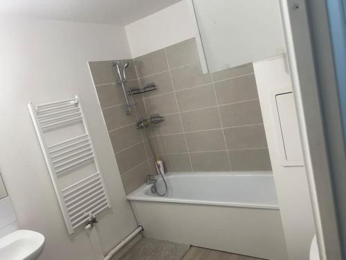 une salle de bain avec une baignoire blanche et des toilettes dans l'établissement Appartement 2 chambres meublé, à Corbeil-Essonnes