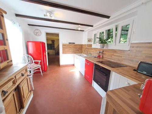 Il comprend une cuisine équipée de placards rouges et d'un réfrigérateur rouge. dans l'établissement Manor House Charentaise, à Sainte-Soulle