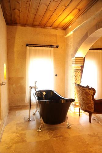 a bathroom with a large black tub in a room at Hira Cave Hotel in Goreme