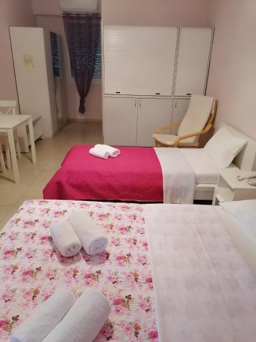 two beds in a room with towels on a rug at Studios Ioulia in Keramotí