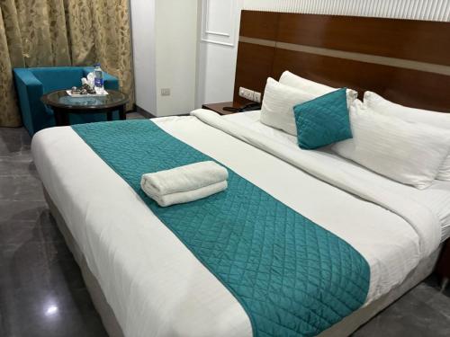 a bedroom with a large bed with a green and white blanket at Asian Suites IFFCO Metro Station Gurugram in Gurgaon