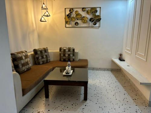 a living room with a couch and a coffee table at Asian Suites IFFCO Metro Station Gurugram in Gurgaon